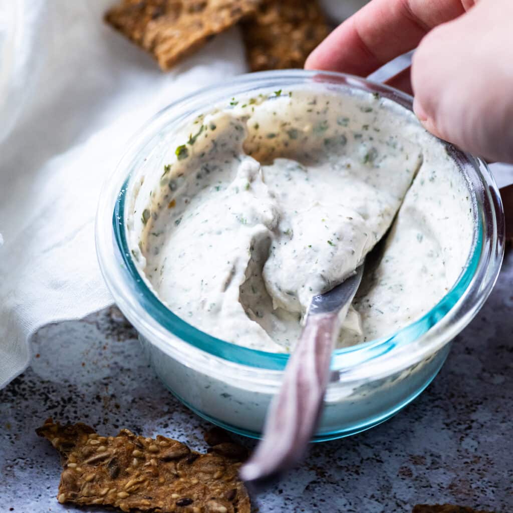 Close up of the vegan garlic herb cream cheese in a bowl.