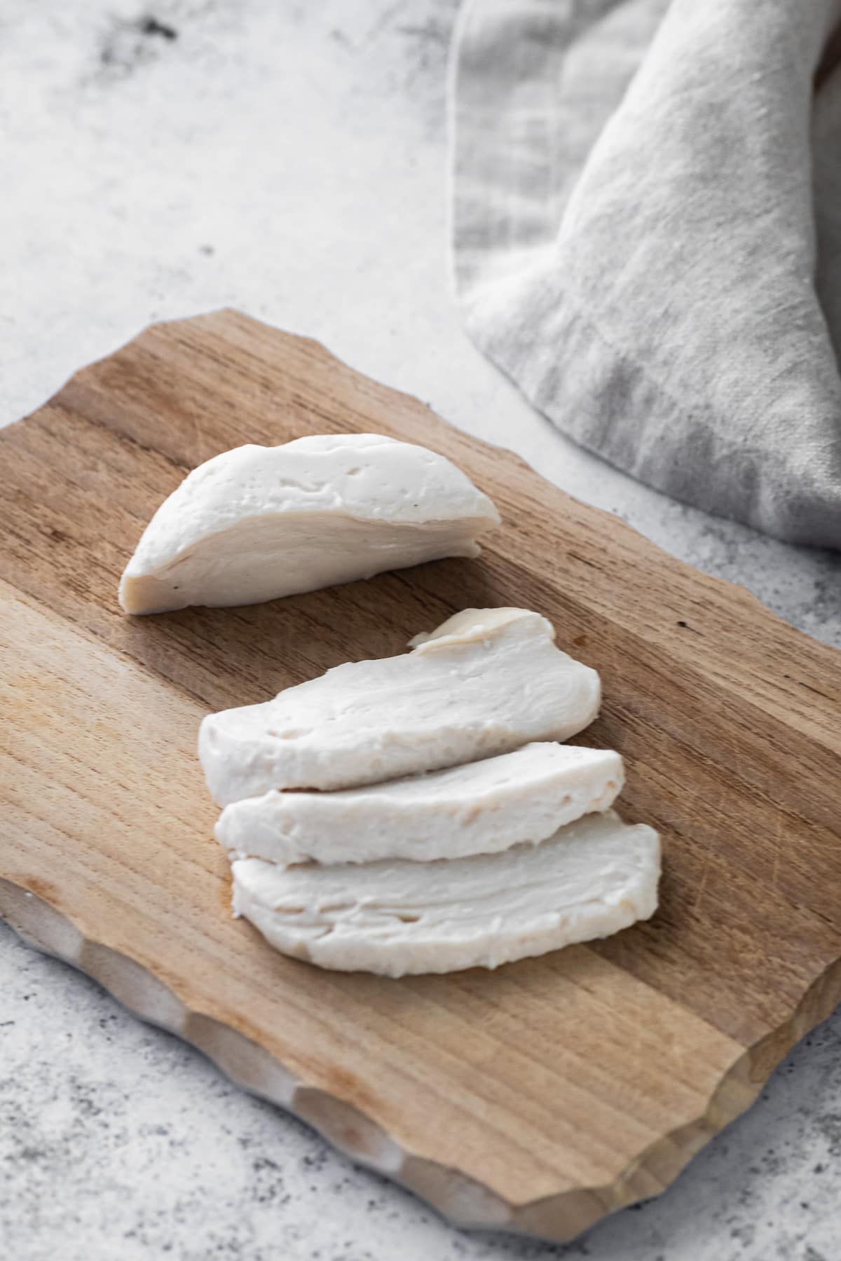 Homemade vegan mozzarella cheese sliced on a cutting board