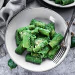 One bowl of spinach pasta with a fork on it.
